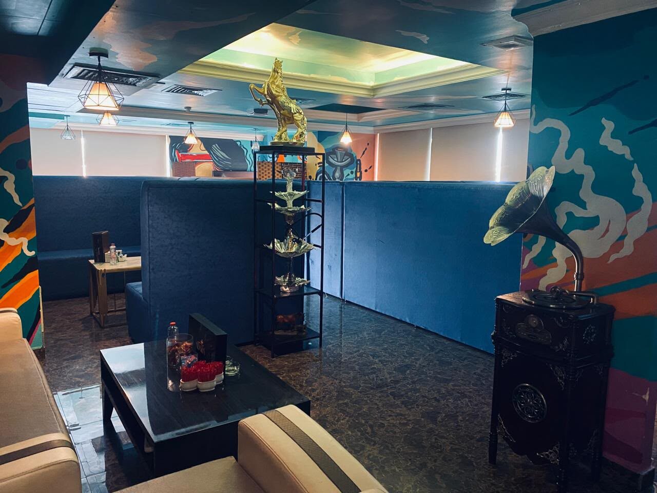 Inside The Cauldron: mural walls, a brass gramophone and warm lamplight