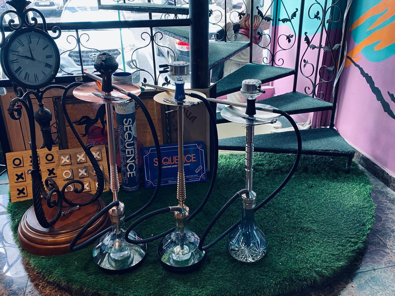 Shisha pipes on green turf with a Sequence board