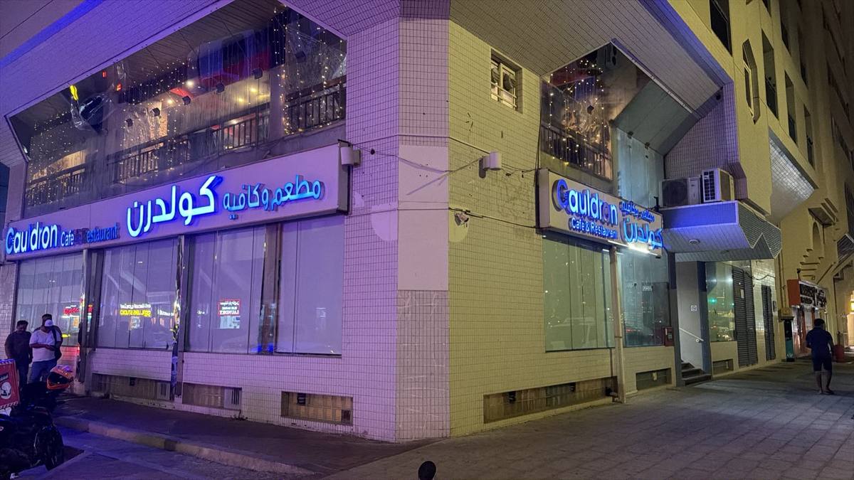 The blue neon Cauldron sign on Mina Road at night
